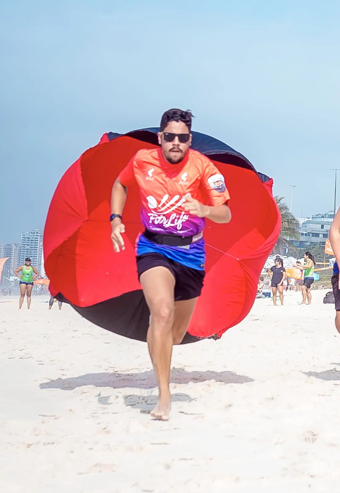 Treino funcional na areia com paraquedas de resistência na FITSLIFE